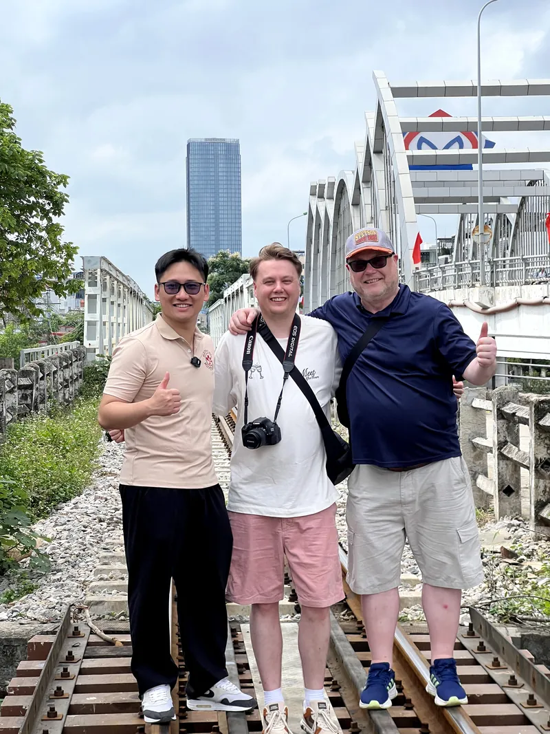 Guides and travelers posing on the railway tracks at Cau Quay swing bridge in Haiphong