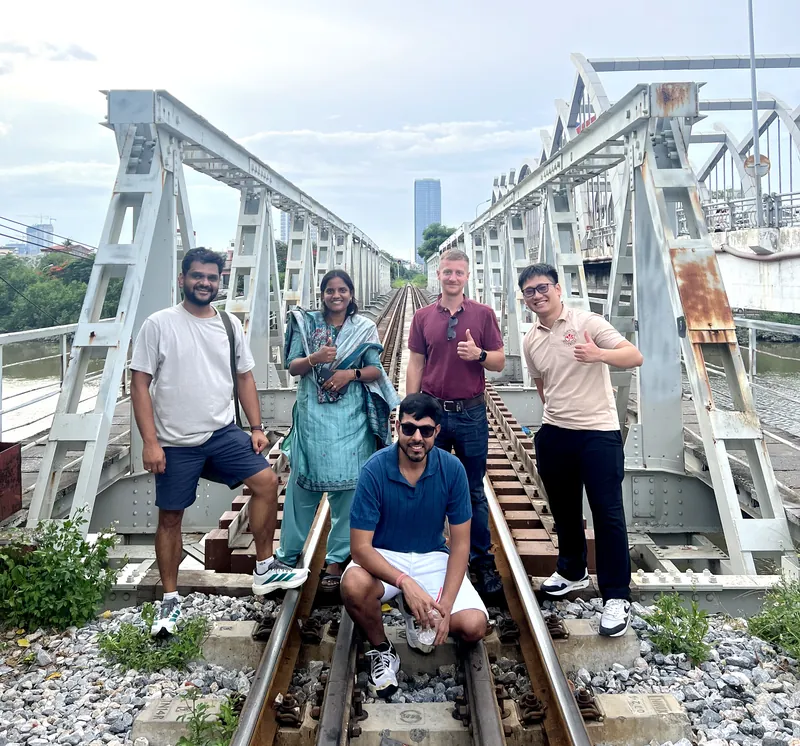 Group of Indian travelers with a guide on the tracks of Cau Quay swing bridge in Haiphong