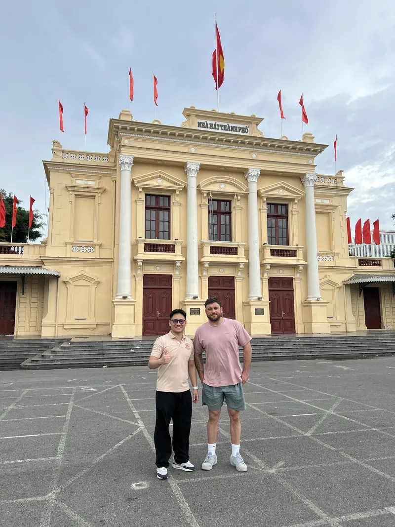 Guide and traveler in front of Haiphong Opera House in daytime